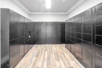 A large room with black lockers and wooden floors